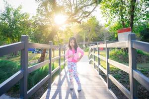 menina asiática em pé sobre uma ponte de madeira foto