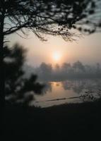 pôr do sol laranja sobre o lago nebuloso foto