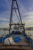 redes de pesca no convés de um barco de pesca no cais foto