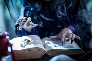 mão da bruxa no livro mágico foto