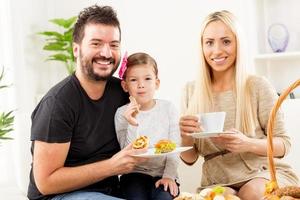 família feliz come massa no café da manhã foto