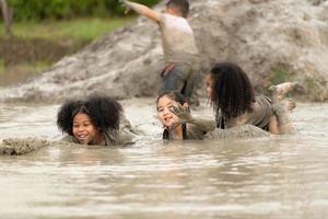 meninas se divertem brincando na lama dos campos da comunidade foto