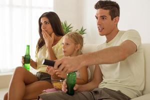 família feliz em casa assistindo tv foto