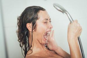 mulher do chuveiro lavando o rosto foto