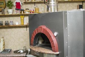 pizza perto do fogão de pedra com fogo. fundo de um restaurante pizzaria tradicional com lareira. foto