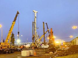 construção de uma ponte no centro da cidade. equipamento de construção é usado para construir um enorme viaduto de blocos de concreto foto