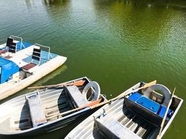 barcos e catamarãs em um lago de lagoa em um canal fluvial com água florida verde estão ancorados na costa foto