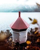 estrutura do farol branco e vermelho perto da massa de água foto