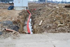 grandes tubos corrugados de plástico vermelho com fios para uma subestação transformadora em um canteiro de obras durante um reparo em uma nova comunidade subterrânea foto