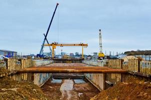 um grande túnel de vala enorme com estruturas de reforço de tubos de ferro grosso de vigas e estruturas no canteiro de obras da linha da estação de metrô subterrânea foto