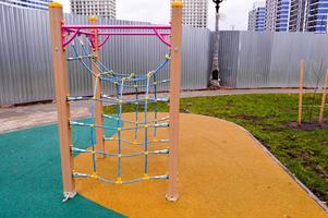 novo parque infantil ao ar livre seguro moderno ao ar livre com equipamentos de ginástica e brinquedos em um novo distrito da cidade no pátio de um novo edifício foto