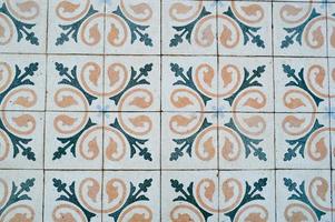 a textura de azulejos quadrados de cerâmica com padrões de ornamentos árabes tradicionais e flores de amarelo e azul com costuras. o fundo foto