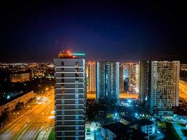 vista da cidade à noite de uma altura. casas altas com janelas panorâmicas e fachadas pintadas. aviso de aeronave na casa foto