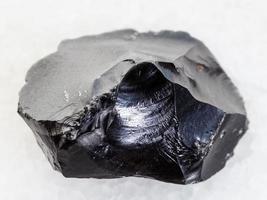 cristal de vidro vulcânico de obsidiana áspera em branco foto