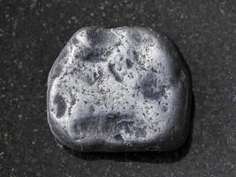 pedra preciosa shungita polida em fundo escuro foto
