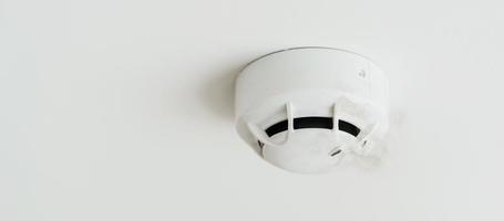 detector de sensor de fumaça montado no telhado em casa ou apartamento. conceito de segurança de segurança e conflagração foto