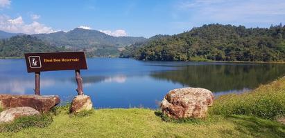 vista paisagística do lago ou rio com colina de montanha verde e fundo de céu azul no reservatório huai bon chiang mai, tailândia. parque, beleza da natureza e papel de parede natural. marco para viajar e relaxar foto