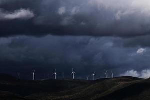 turbinas eólicas em colina sob nuvens pesadas foto