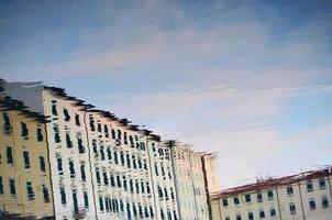 reflexo de um edifício branco em uma poça de rua durante o dia foto