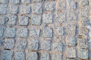 textura de uma parede de pedra, estradas de pedras, tijolos, paralelepípedos, telhas com costuras arenosas de cinza antigo natural amarelo velho com bordas afiadas. o fundo foto