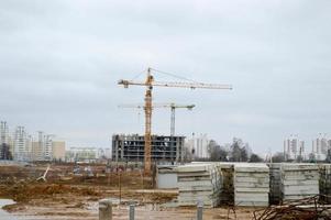 um grande canteiro de obras moderno na construção de edifícios e casas com eletrodomésticos e muitos guindastes e materiais de construção poderosos industriais estacionários e de grande torre foto