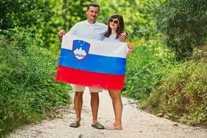 casal segura bandeira eslovena no parque nacional de triglav, eslovênia. foto