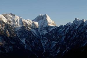 incrível vista de um pico de montanha durante o pôr do sol. cume de difícil acesso para alpinistas. alpinismo e escaladores. céu azul e cores vibrantes. tiro cinematográfico. mais aventura na vida. montanha prenj. foto