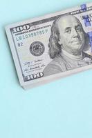 notas de dólar americano de um novo design com uma faixa azul no meio está em um fundo azul claro foto