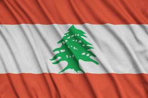 A bandeira do líbano é retratada em um tecido esportivo com muitas dobras. bandeira da equipe esportiva foto