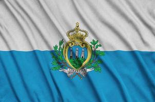 a bandeira de san marino é retratada em um tecido esportivo com muitas dobras. bandeira da equipe esportiva foto