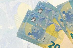 As notas de 20 euros estão empilhadas sobre o fundo de uma grande nota semitransparente. apresentação abstrata da moeda nacional foto
