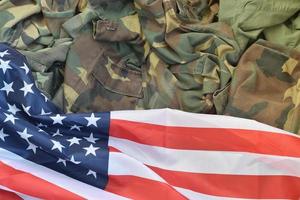 bandeira dos estados unidos da américa e jaqueta de uniforme militar dobrada. bandeira de fundo conceitual de símbolos militares para feriados patrióticos americanos foto