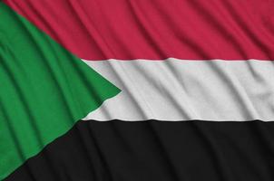 a bandeira do sudão é retratada em um tecido esportivo com muitas dobras. bandeira da equipe esportiva foto
