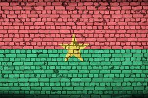 bandeira de burkina faso é pintada em uma parede de tijolos antigos foto