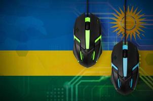 bandeira de ruanda e dois ratos com luz de fundo. jogos cooperativos online. equipe de esportes cibernéticos foto