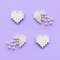 alguns corações feitos de cubos de açúcar encontram-se em um fundo violeta pastel moderno foto