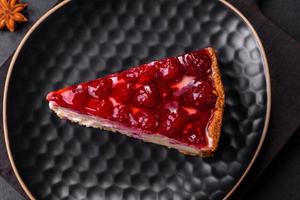 cheesecake saboroso caseiro com geléia e framboesa em um prato preto foto