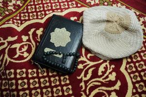 al quran com a tradução da Indonésia em um tapete de oração. Alcorão é um livro sagrado islâmico para muçulmanos. foto