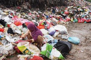 Sangatta, East Kalimantan, Indonésia, 2020 - uma catadora está separando itens que ainda estão aptos para uso ou venda foto