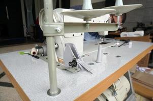 um velho consertando uma máquina de costura, com foco seletivo foto