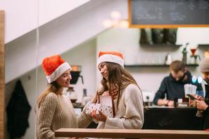 a garota dá um presente para sua amiga no caffe foto