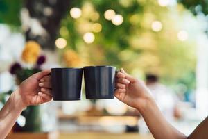 closeup imagem de um povo tilintando xícaras de café juntos no café foto