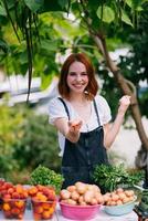 vendedor de mulher no balcão com legumes. conceito de pequena empresa foto