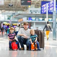 pai e dois meninos irmãos no aeroporto