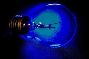 lâmpada única iluminada por trás por luz azul foto