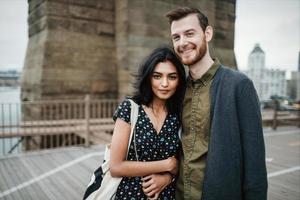 casal atraente se abraçando na ponte da cidade foto