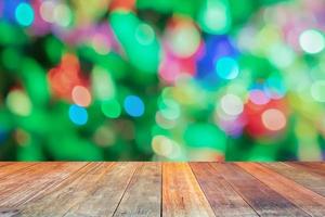 tampo de mesa de madeira vazio com árvore de natal desfocada com fundo claro bokeh foto