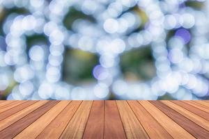 tampo de mesa de madeira vazio com árvore de natal desfocada com fundo claro bokeh foto