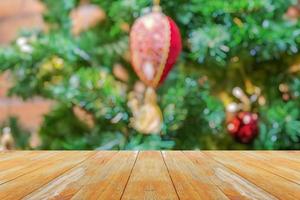 tampo de mesa de madeira vazio com árvore de natal desfocada com fundo claro bokeh foto