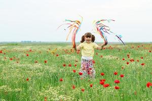 menina feliz brincando no prado primavera foto